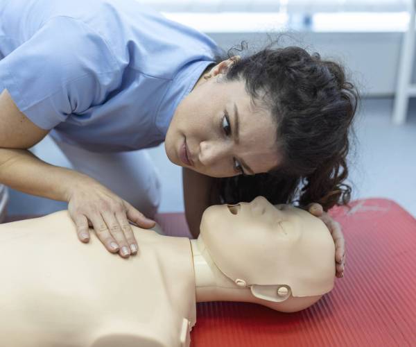 CPR class with instructors talking and demonstrating firt aid, compressions ans reanimation procedure. Cpr dummy